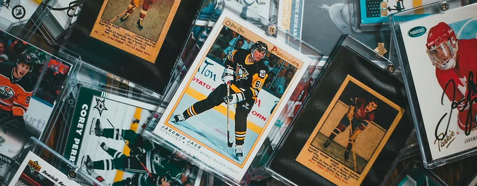 Vintage and modern sports cards in protective holders spread across a table at the CardRevive Lab.
