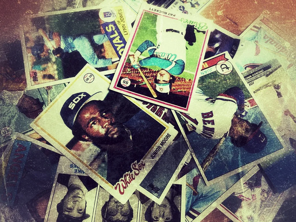 A pile of worn vintage baseball cards with creased corners and faded surfaces.