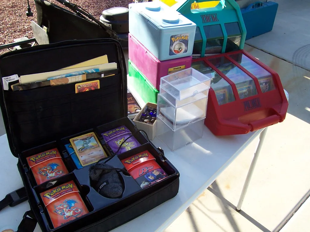 An open card case packed with sealed Pokemon Trading Card Game theme decks and storage boxes on a table.