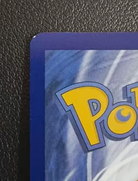 Close-up of a Pokemon card back corner with wear at the tip before corner correction