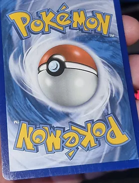 Pokemon card back with whitening flecks along the blue border edges before edge repair